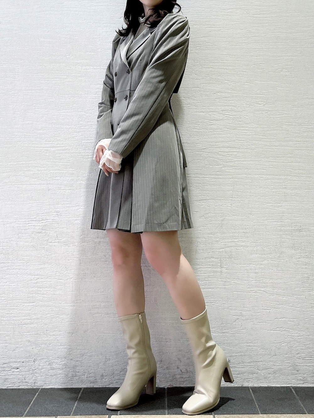 グレー系のワンピース、ホワイト系のTシャツ/カットソー、ホワイト系のブーツを着用したレディースの秋コーディネートの5枚目の写真