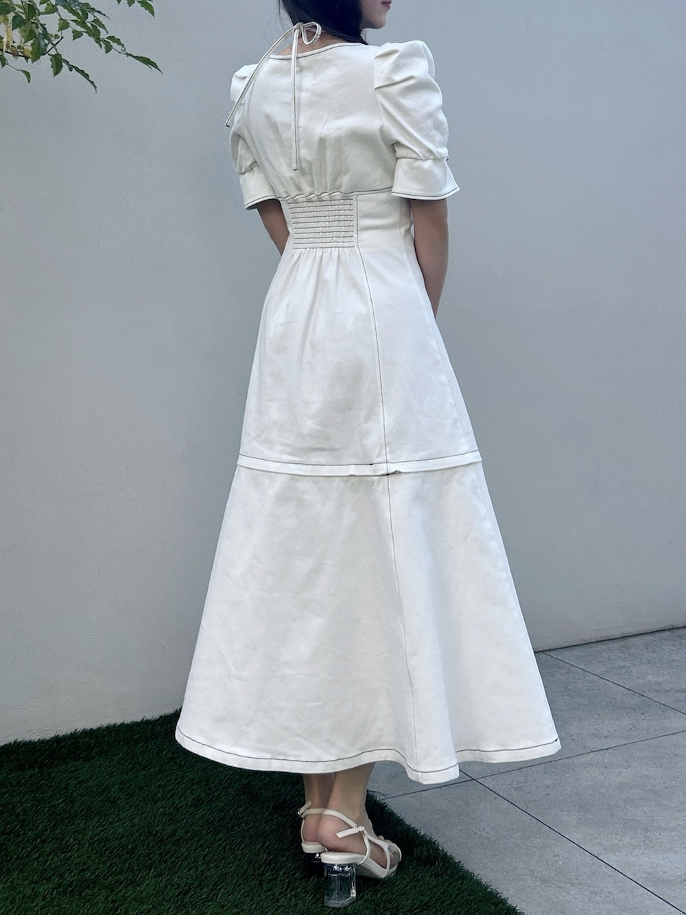 ホワイト系のワンピース、ホワイト系のサンダル、イエロー系のハンドバッグを着用したレディースの春コーディネートの4枚目の写真