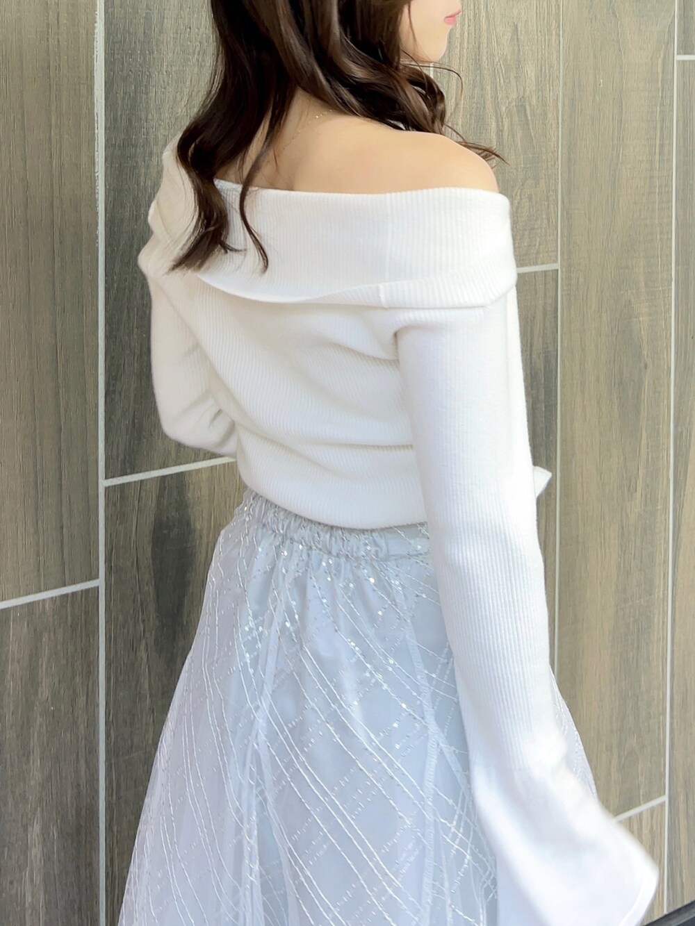 ホワイト系のニット/セーター、グレー系のスカート、ホワイト系のブーツを着用したレディースの冬コーディネートの10枚目の写真