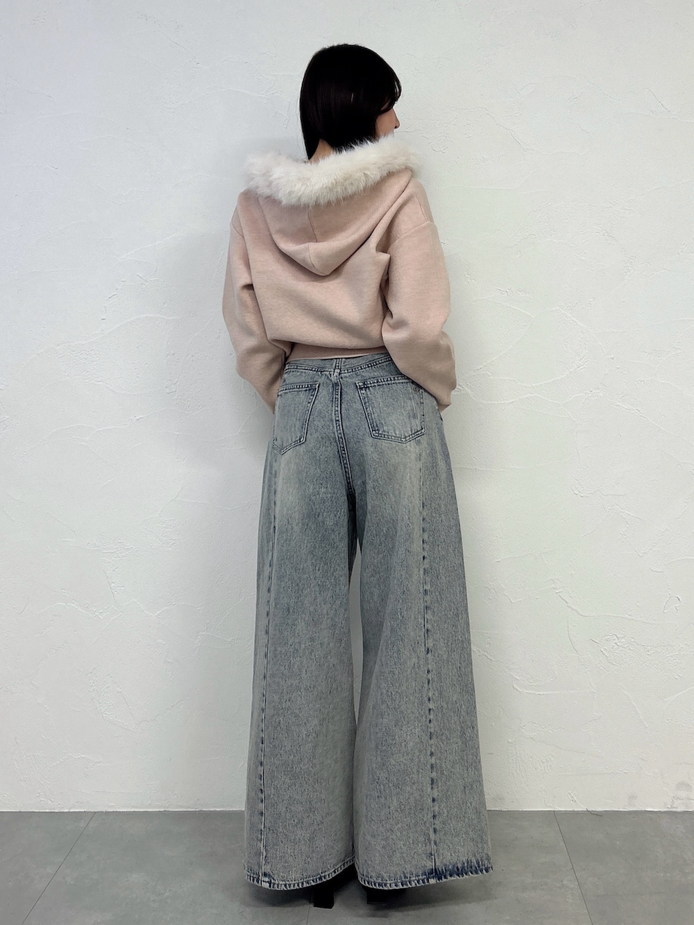 ピンク系のニット/セーター、ブルー系のデニムパンツを着用したレディースの冬コーディネートの5枚目の写真