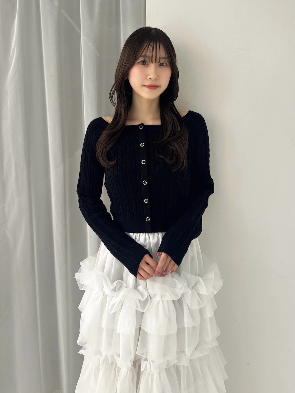 ブラック系のニット/セーター、ホワイト系のスカート、ブラック系のサンダルを着用したレディースの冬コーディネートの6枚目の写真