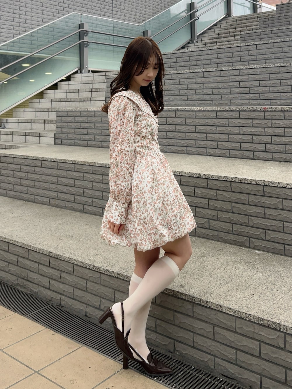 オレンジ系のワンピース、ブラウン系のローファーを着用したレディースの春コーディネートの3枚目の写真