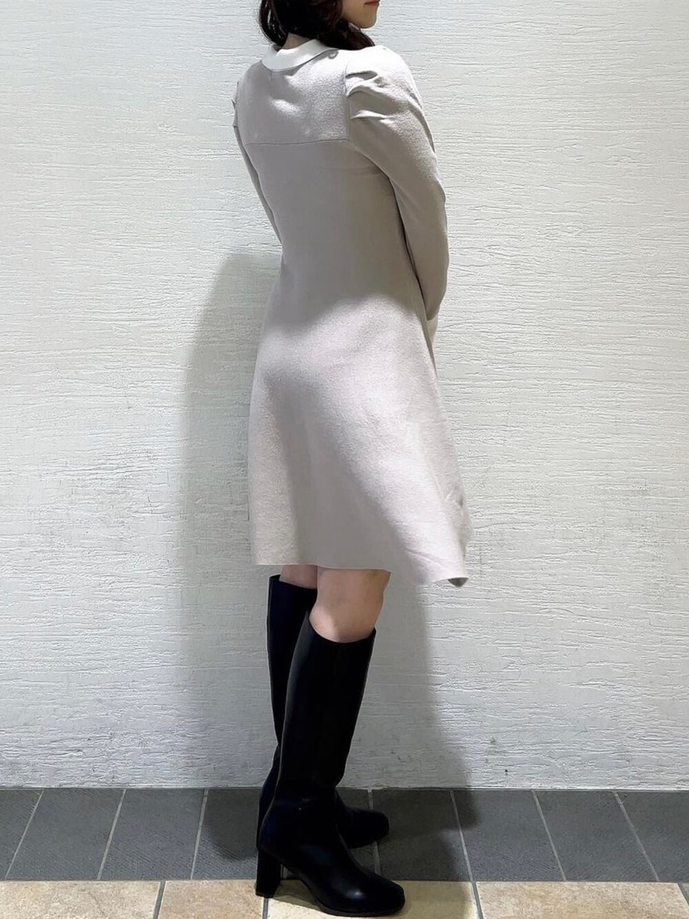 グレー系のワンピース、ブラック系のブーツを着用したレディースの冬コーディネートの5枚目の写真