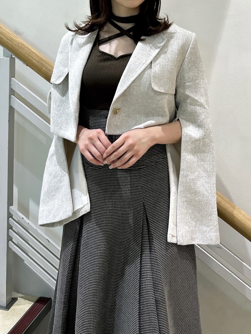 ブラウン系のワンピース、ホワイト系のテーラードジャケット、ベージュ系のパンプスを着用したレディースの秋コーディネートの6枚目の写真