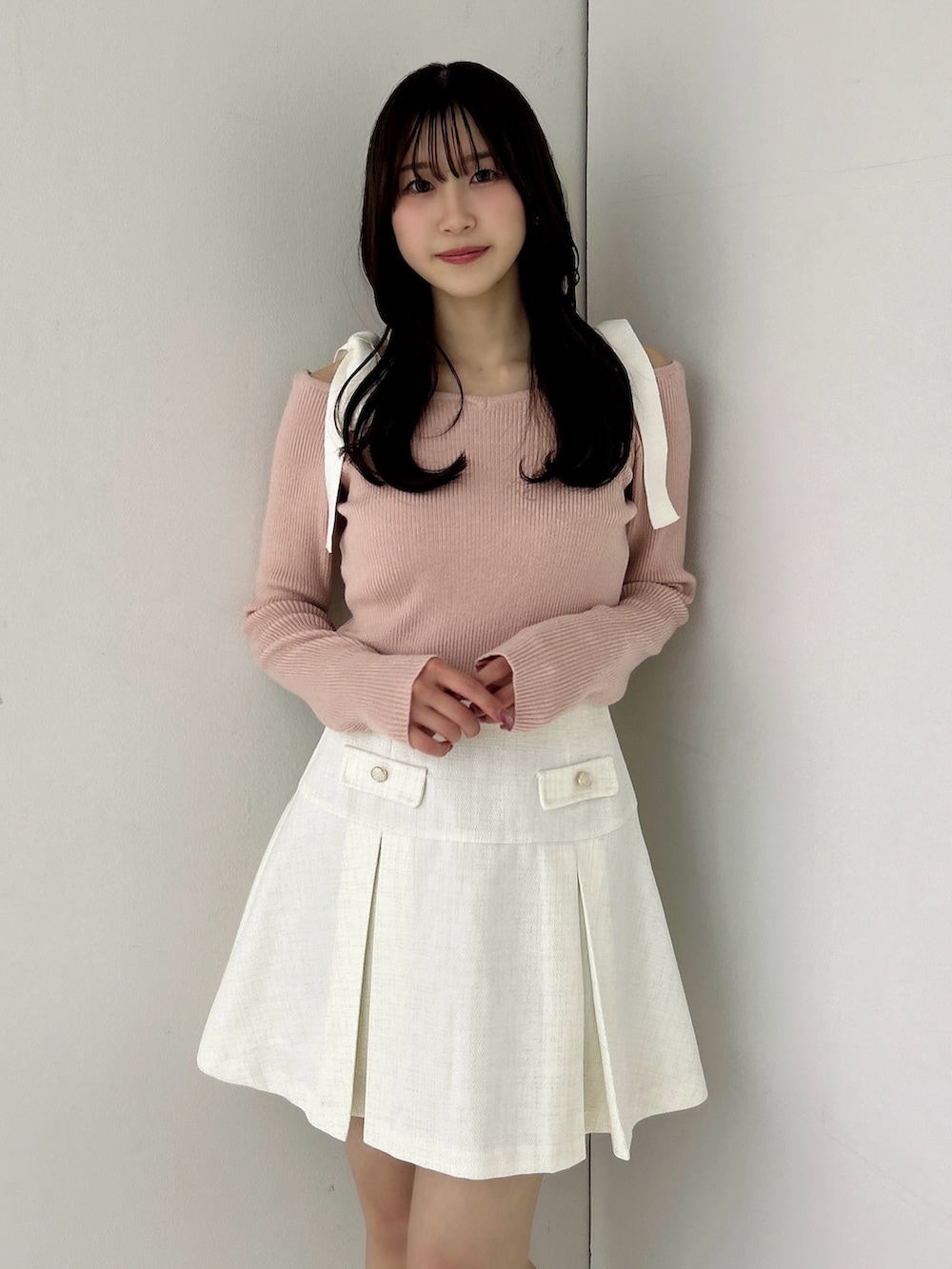 ピンク系のニット/セーター、ホワイト系のスカート、ホワイト系のブーツを着用したレディースの冬コーディネートの9枚目の写真