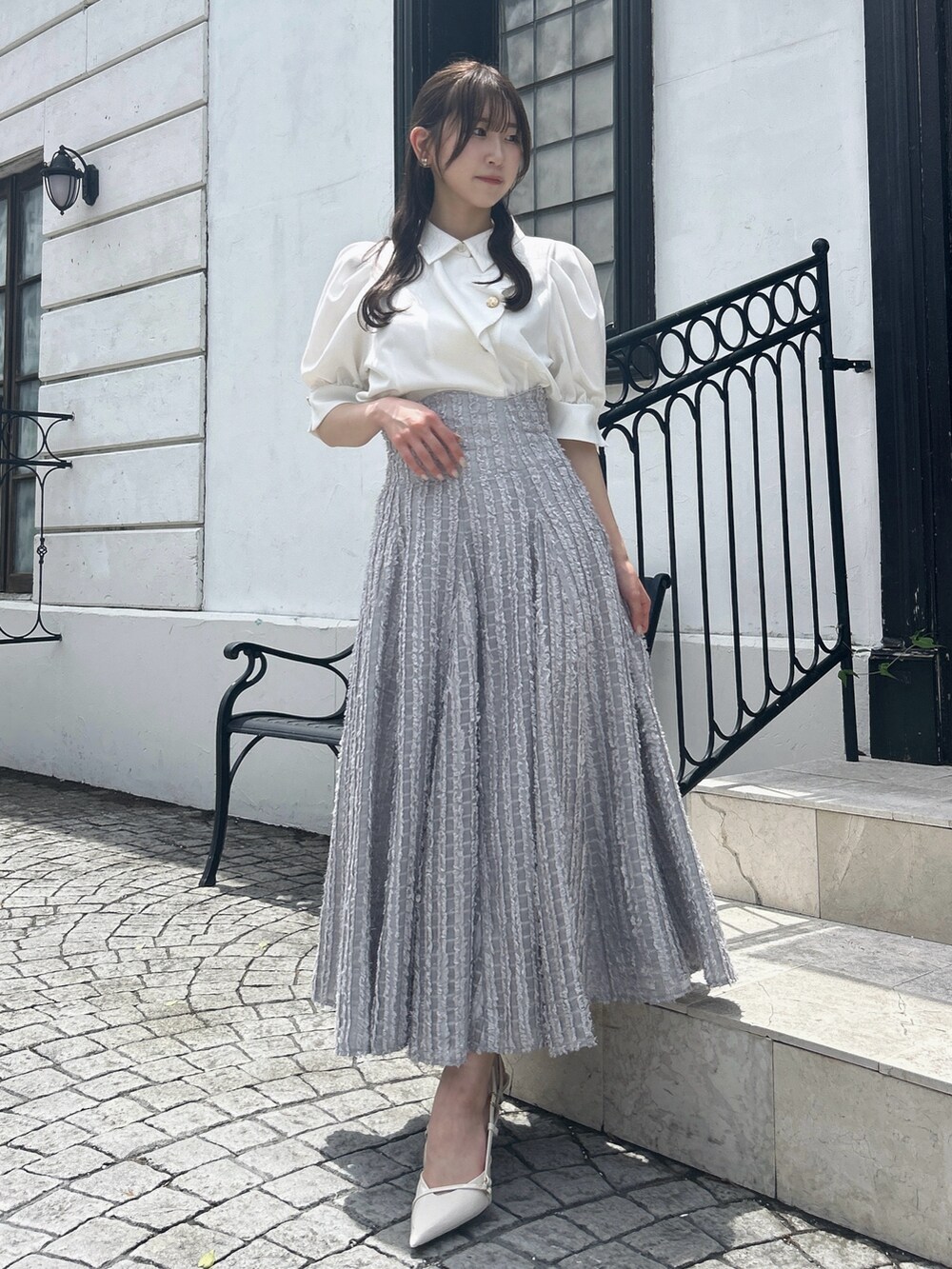 グレー系のスカート、ホワイト系のシャツ/ブラウスを着用したレディースの夏コーディネートの3枚目の写真