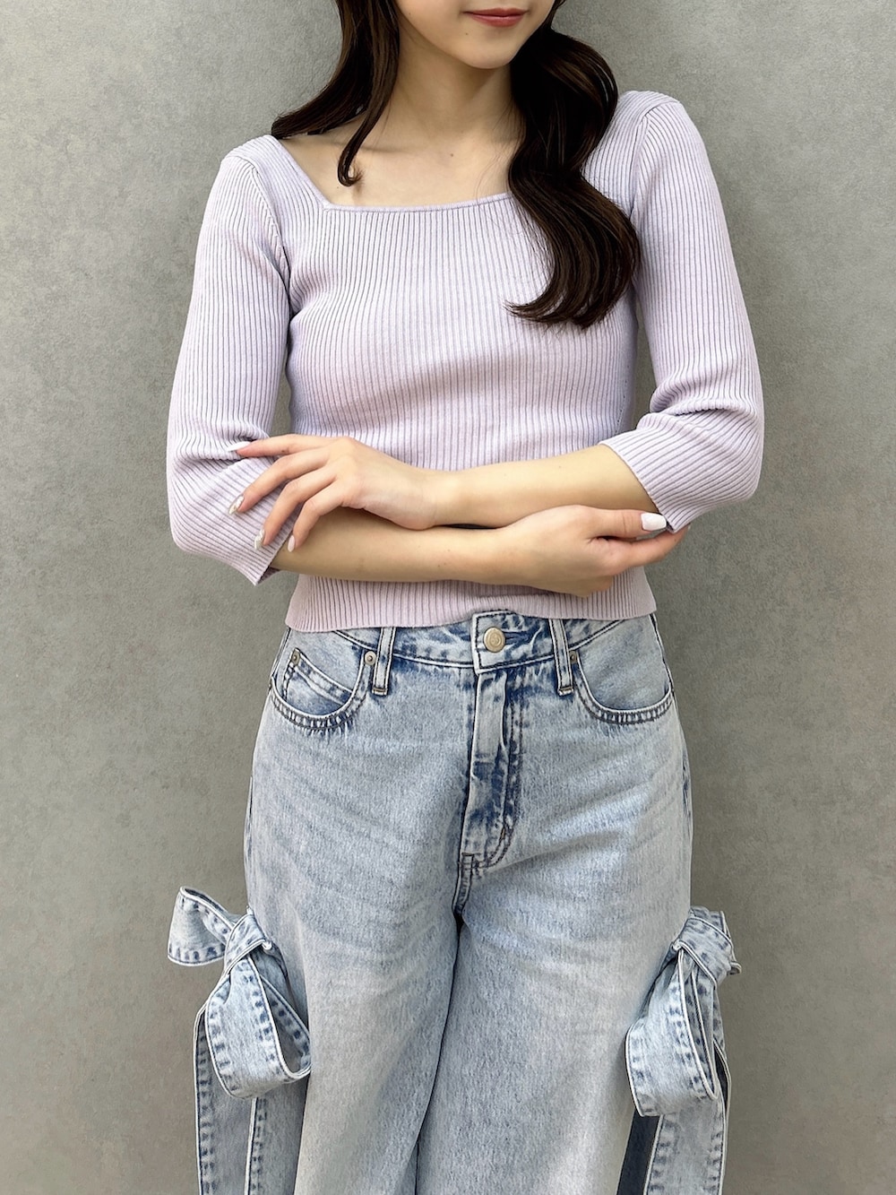 パープル系のニット/セーター、ブルー系のデニムパンツ、ホワイト系のパンプスを着用したレディースの冬コーディネートの8枚目の写真