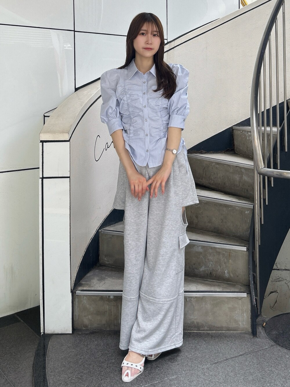 ブルー系のシャツ/ブラウス、グレー系のカーゴパンツ、ホワイト系のパンプスを着用したレディースの夏コーディネートの3枚目の写真