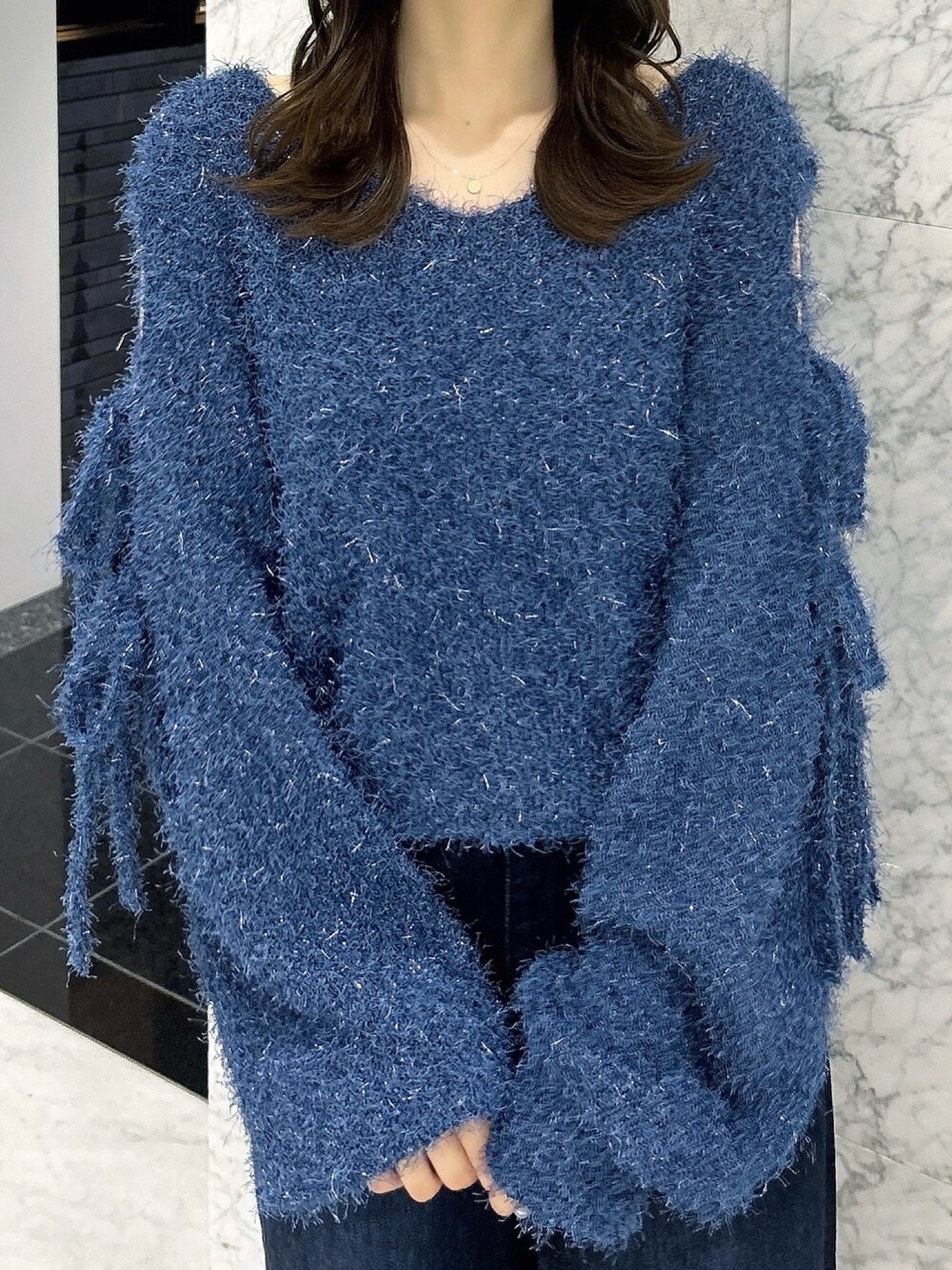 ブルー系のニット/セーター、ブルー系のデニムパンツ、ホワイト系のパンプスを着用したレディースの夏コーディネートの6枚目の写真