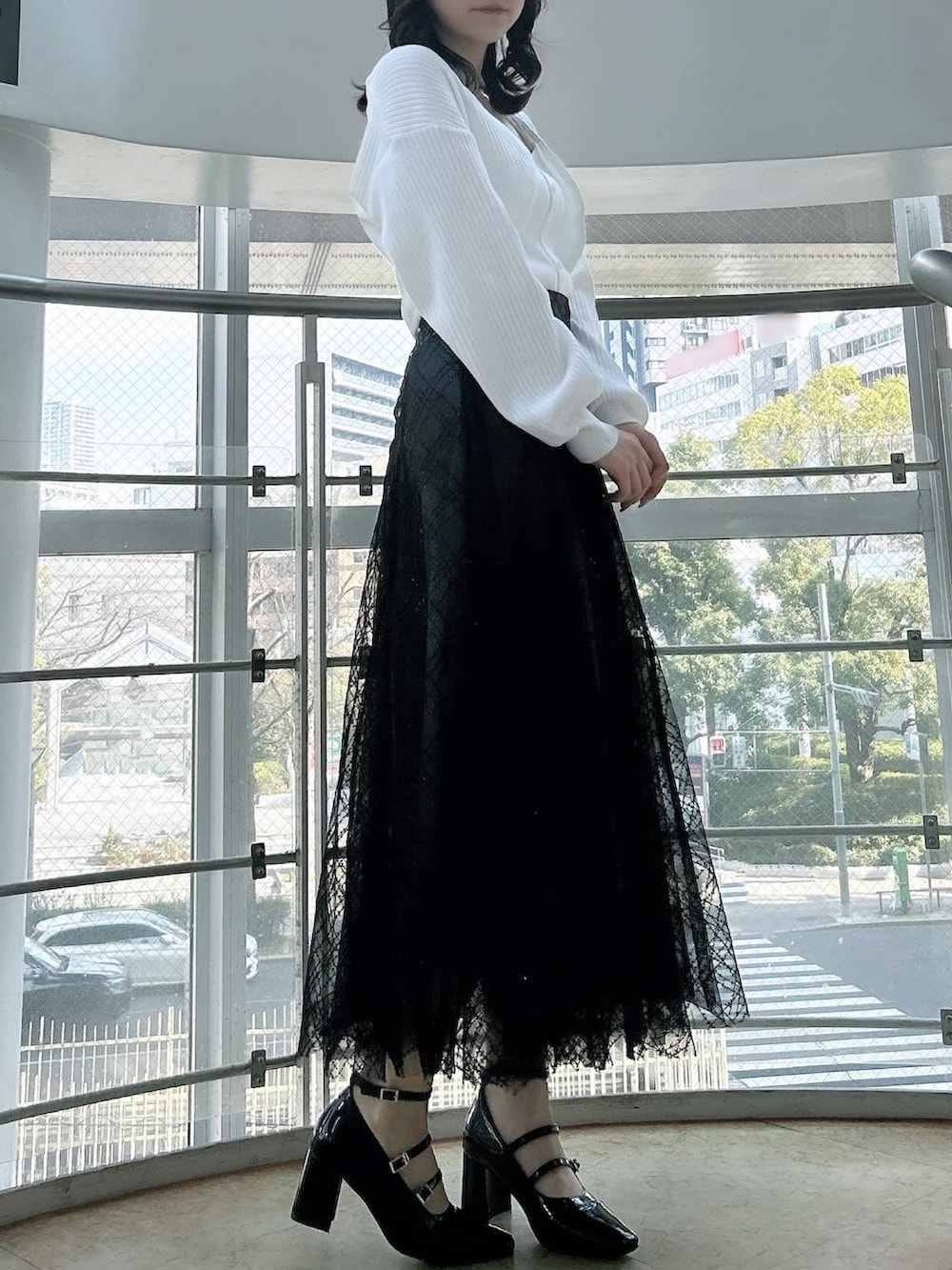 ホワイト系のアンサンブル、ブラック系のスカート、ブラック系のパンプスを着用したレディースの春コーディネートの3枚目の写真