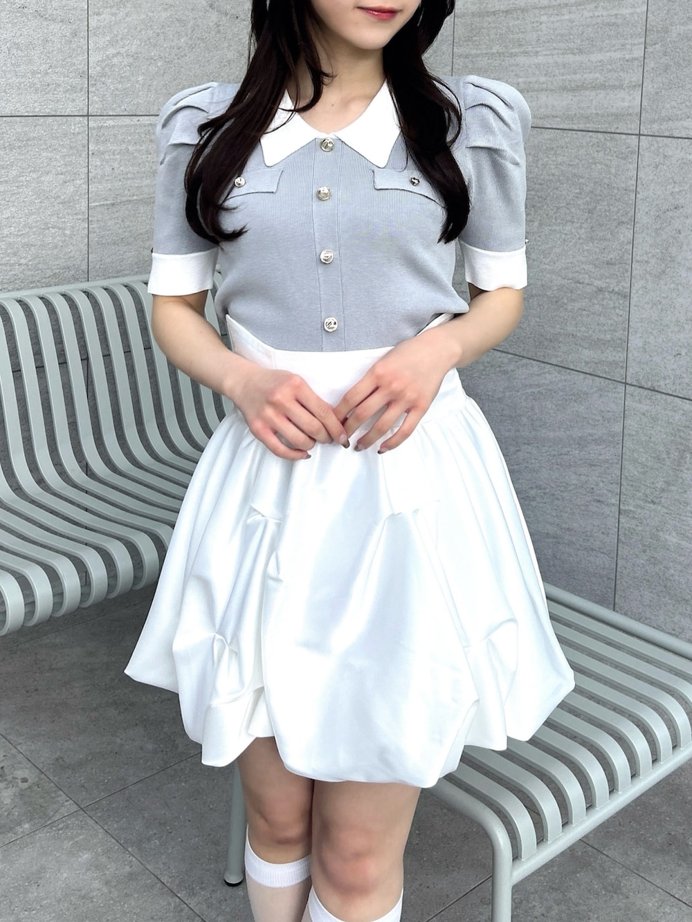 グレー系のニット/セーター、ホワイト系のスカートを着用したレディースの冬コーディネートの6枚目の写真