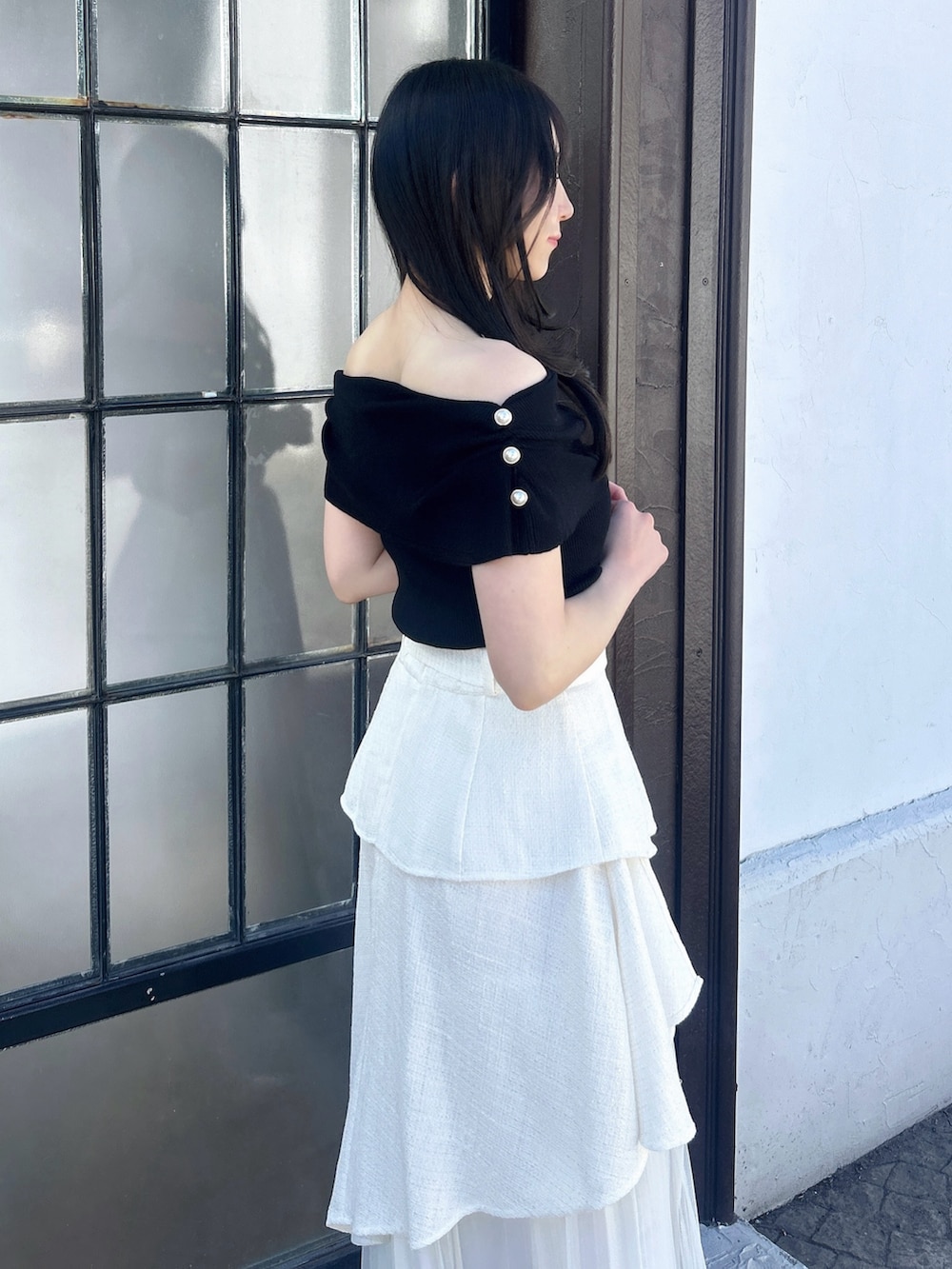 ホワイト系のスカート、ブラック系のニット/セーターを着用したレディースの冬コーディネートの8枚目の写真