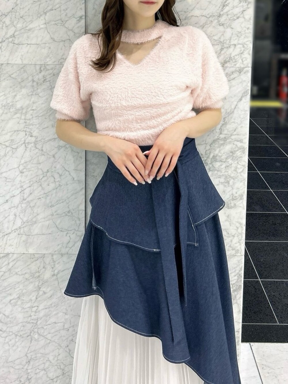 ブルー系のスカート、ブラック系のパンプス、ピンク系のニット/セーターを着用したレディースの秋コーディネートの6枚目の写真