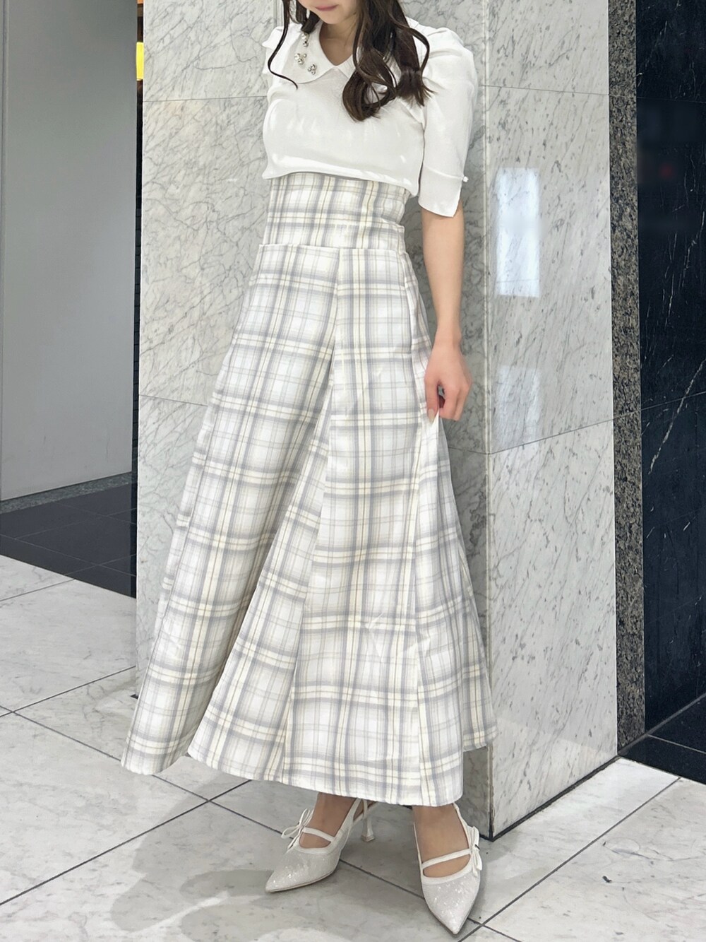 ホワイト系のニット/セーター、イエロー系のスカート、ホワイト系のパンプスを着用したレディースの春コーディネートの3枚目の写真