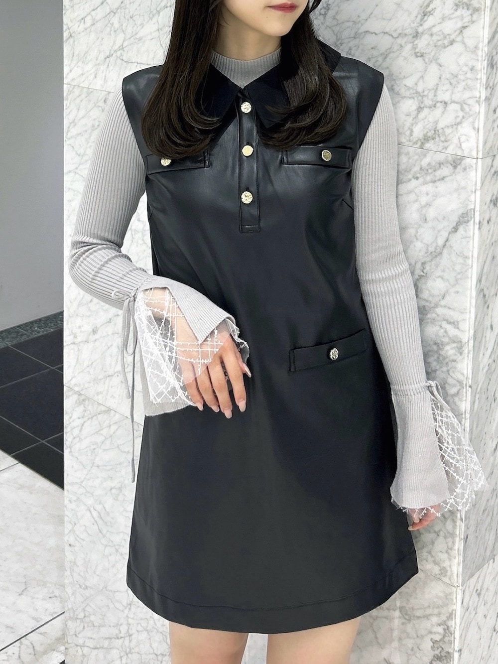 グレー系のニット/セーター、ブラック系のワンピース、ブラック系のパンプスを着用したレディースの秋コーディネートの8枚目の写真