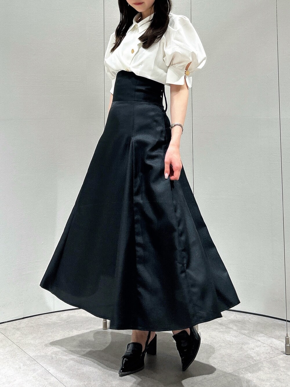 ホワイト系のシャツ/ブラウス、ブラック系のスカート、ブラック系のローファーを着用したレディースの春コーディネートの4枚目の写真