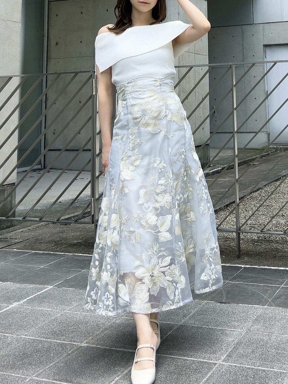 ホワイト系のニット/セーター、グレー系のスカート、ホワイト系のパンプスを着用したレディースの夏コーディネートの4枚目の写真