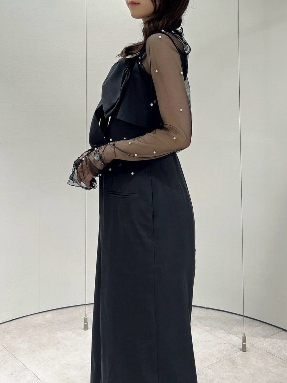 ブラック系のパンプス、ブラック系のTシャツ/カットソー、グレー系のワンピースを着用したレディースの秋コーディネートの9枚目の写真