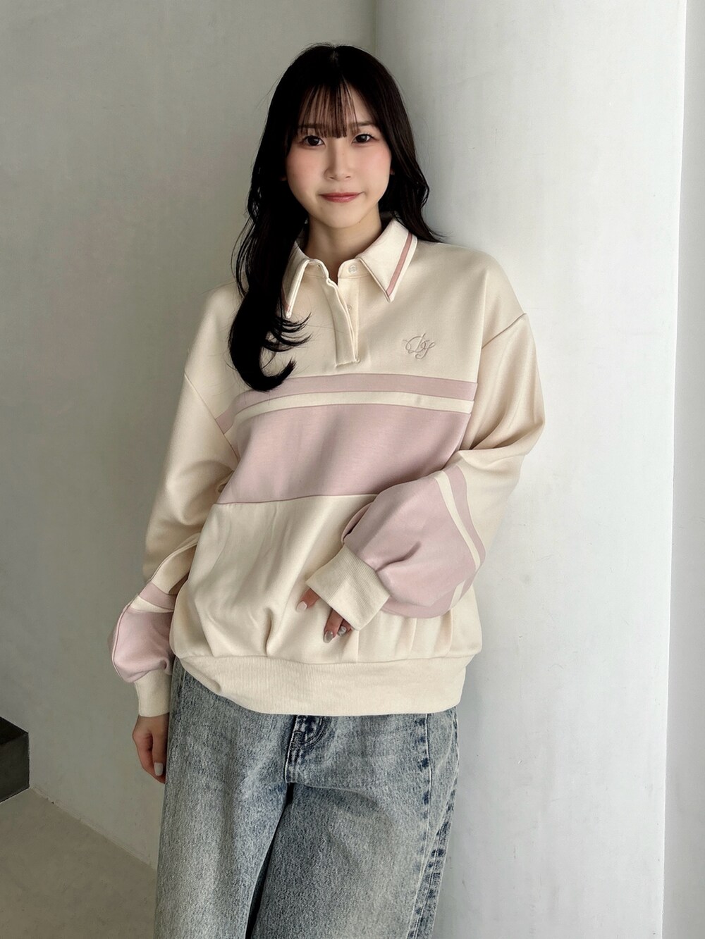 ブルー系のデニムパンツ、ホワイト系のハンドバッグ、ピンク系のスウェットを着用したレディースの冬コーディネートの6枚目の写真