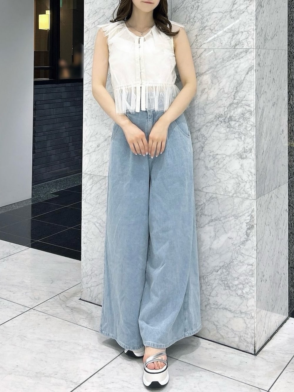 ホワイト系のタンクトップ、ホワイト系のキャミソール、ブルー系のデニムパンツを着用したレディースの夏コーディネートの2枚目の写真
