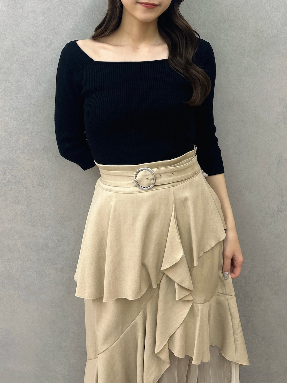 ブラック系のニット/セーター、ベージュ系のスカート、ブラック系のパンプスを着用したレディースの冬コーディネートの10枚目の写真