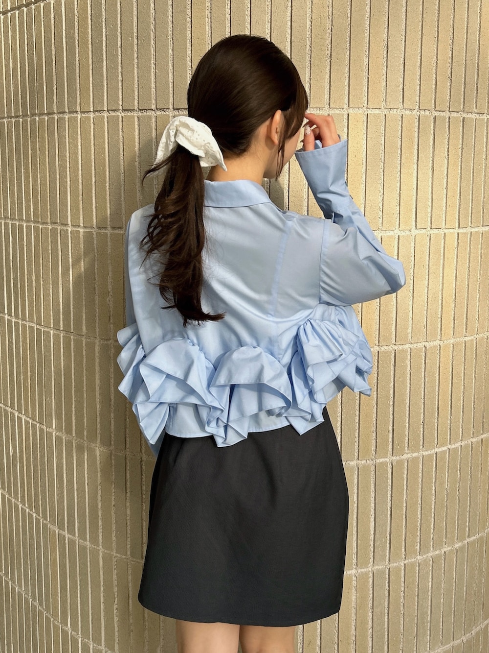 ブルー系のシャツ/ブラウス、グレー系のスカート、ブラック系のブーツを着用したレディースの春コーディネートの8枚目の写真