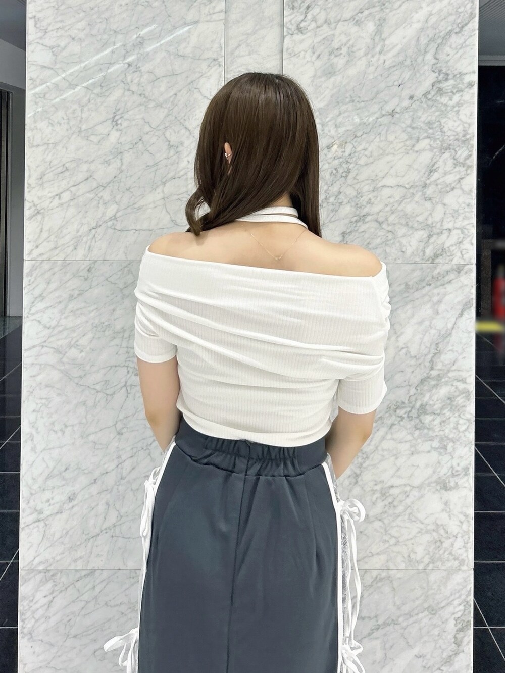 グレー系のスカート、ホワイト系のTシャツ/カットソー、ブラック系のパンプスを着用したレディースの秋コーディネートの10枚目の写真