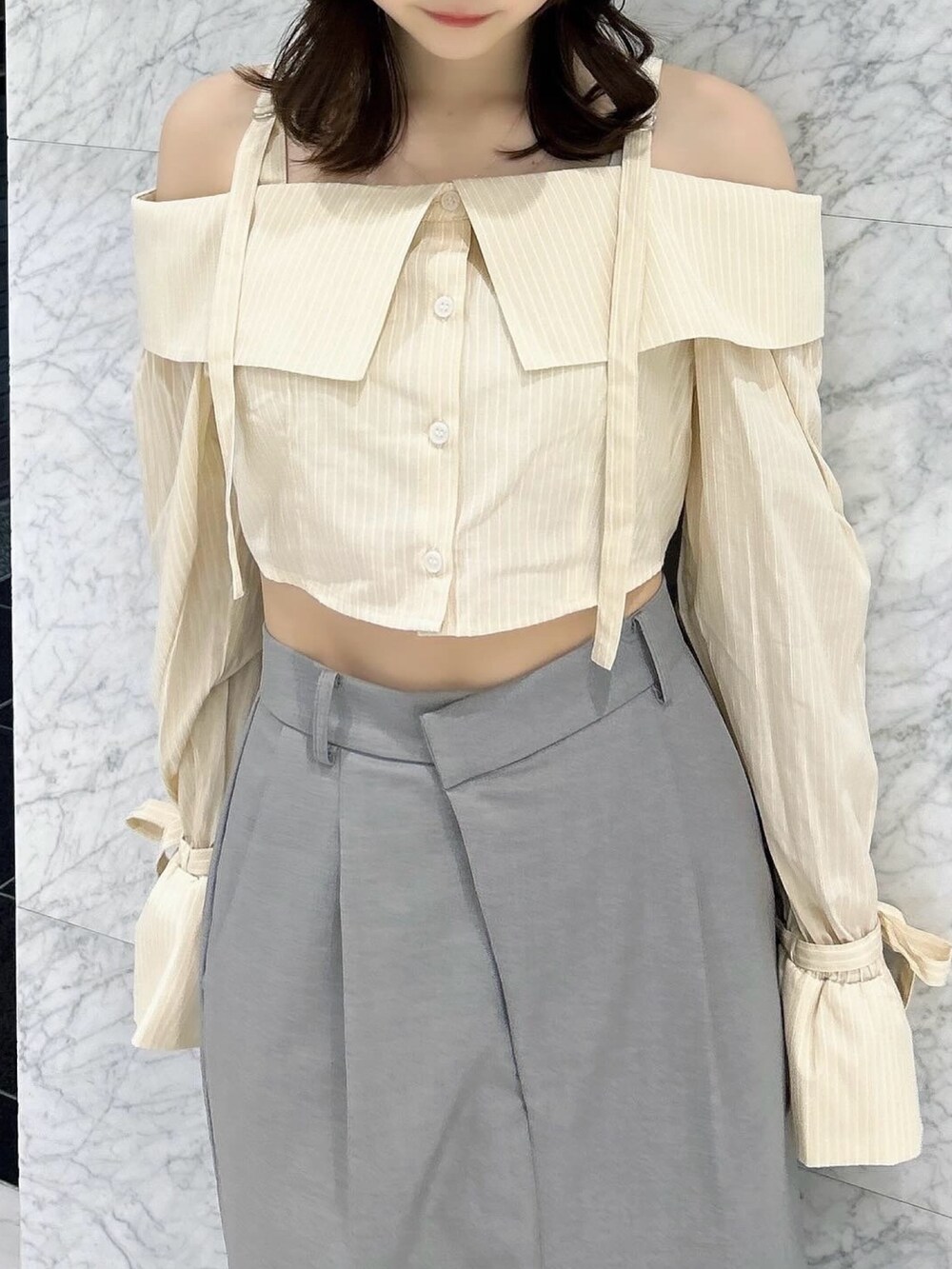 グレー系のスカート、シルバー系のパンプス、イエロー系のシャツ/ブラウスを着用したレディースの春コーディネートの8枚目の写真