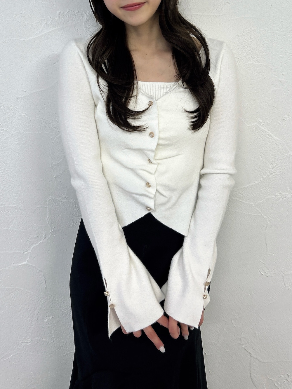 ホワイト系のニット/セーター、ブラック系のスカート、ブラック系のサンダルを着用したレディースの春コーディネートの5枚目の写真