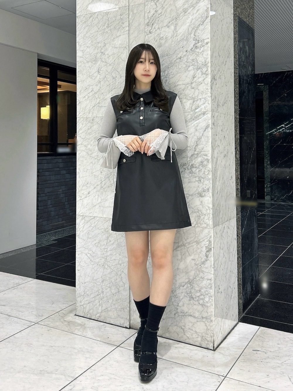 グレー系のニット/セーター、ブラック系のワンピース、ブラック系のパンプスを着用したレディースの秋コーディネートの2枚目の写真