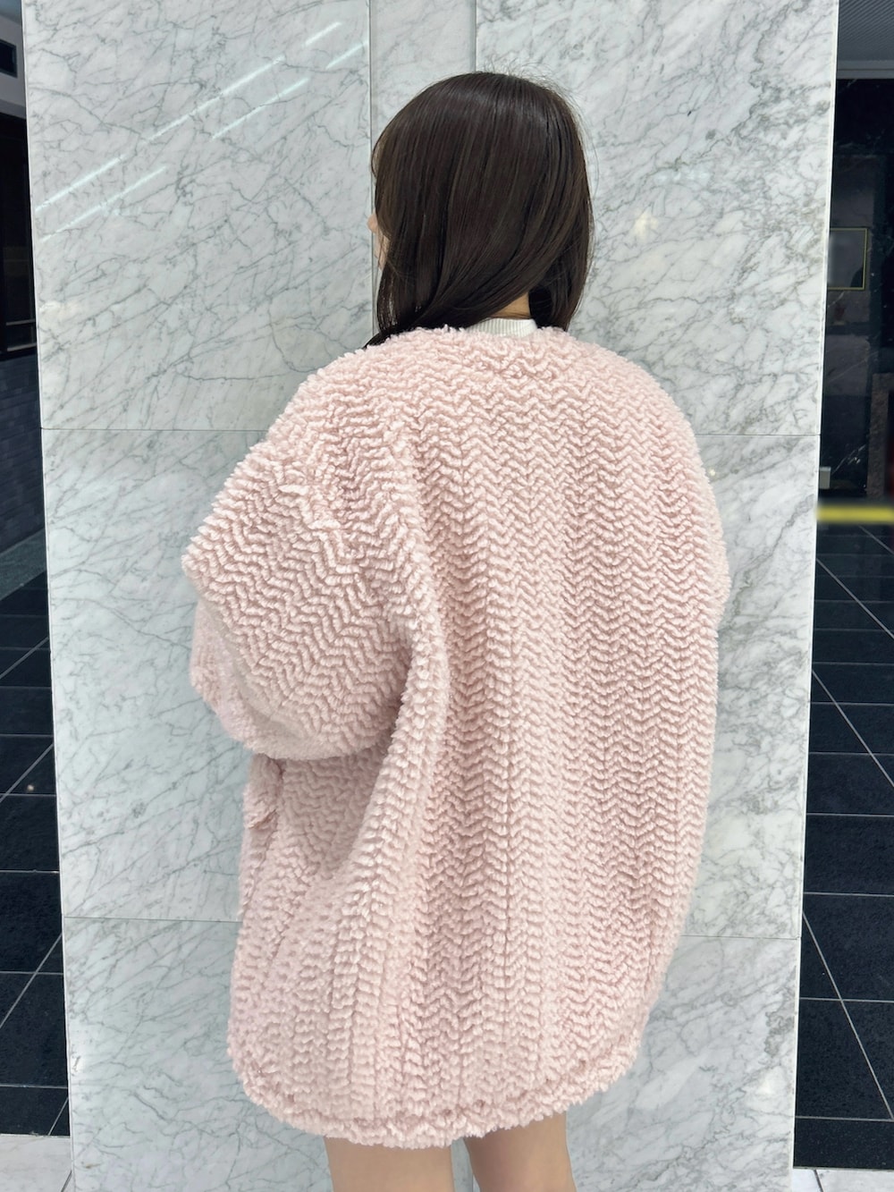 ピンク系のブルゾン、ブラック系のその他パンツ、ホワイト系のニット/セーターを着用したレディースの秋コーディネートの9枚目の写真