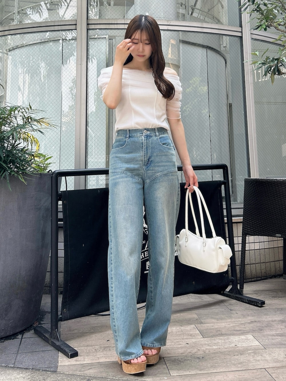 ホワイト系のTシャツ/カットソー、ブルー系のデニムパンツ、ブラウン系のサンダルを着用したレディースの夏コーディネートの2枚目の写真