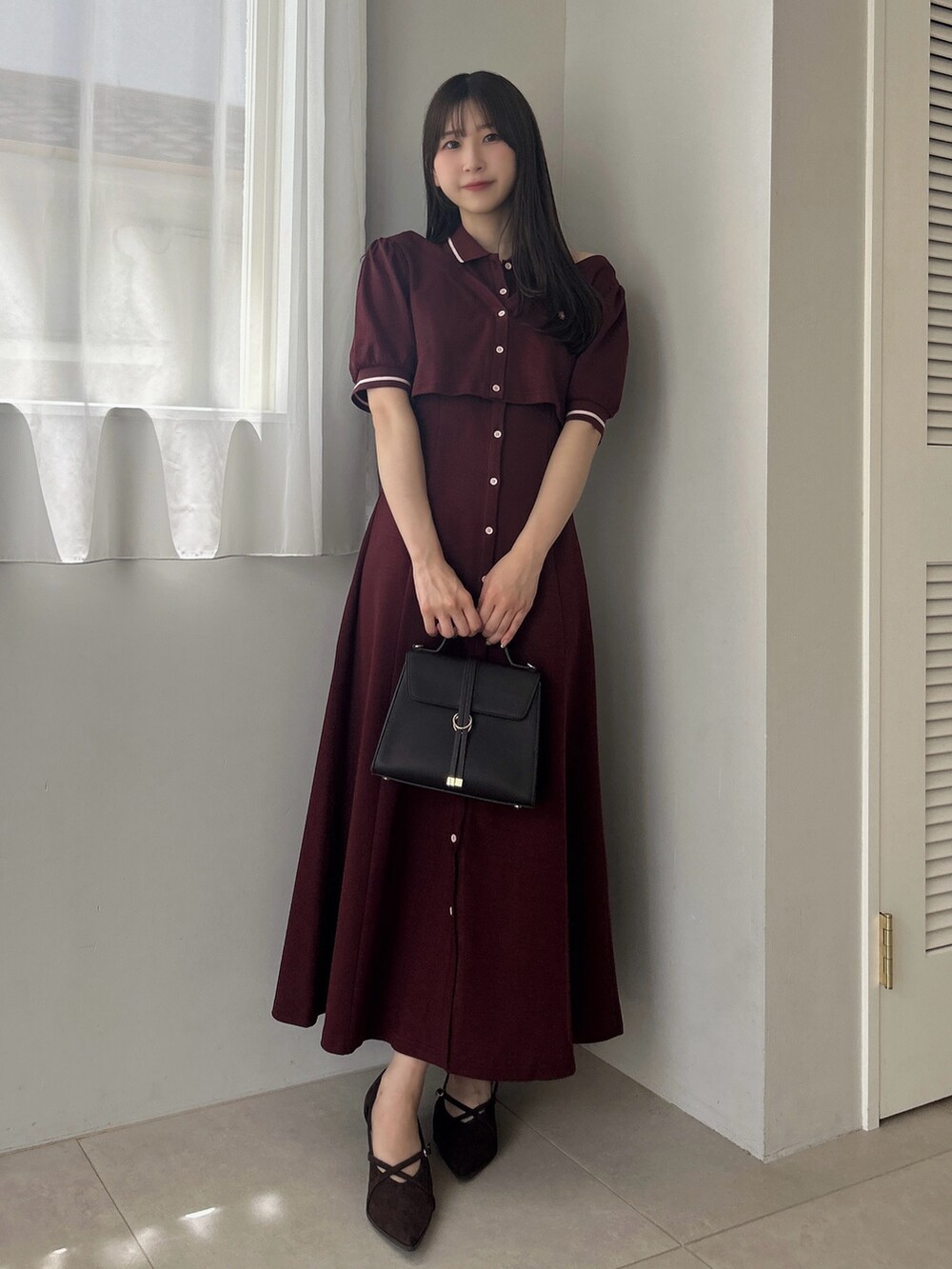 レッド系のワンピース、ブラウン系のショルダーバッグを着用したレディースの夏コーディネートの2枚目の写真