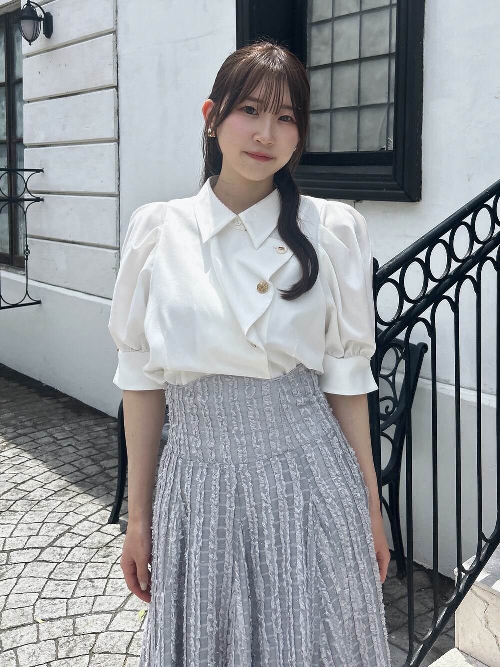 グレー系のスカート、ホワイト系のシャツ/ブラウスを着用したレディースの夏コーディネートの5枚目の写真