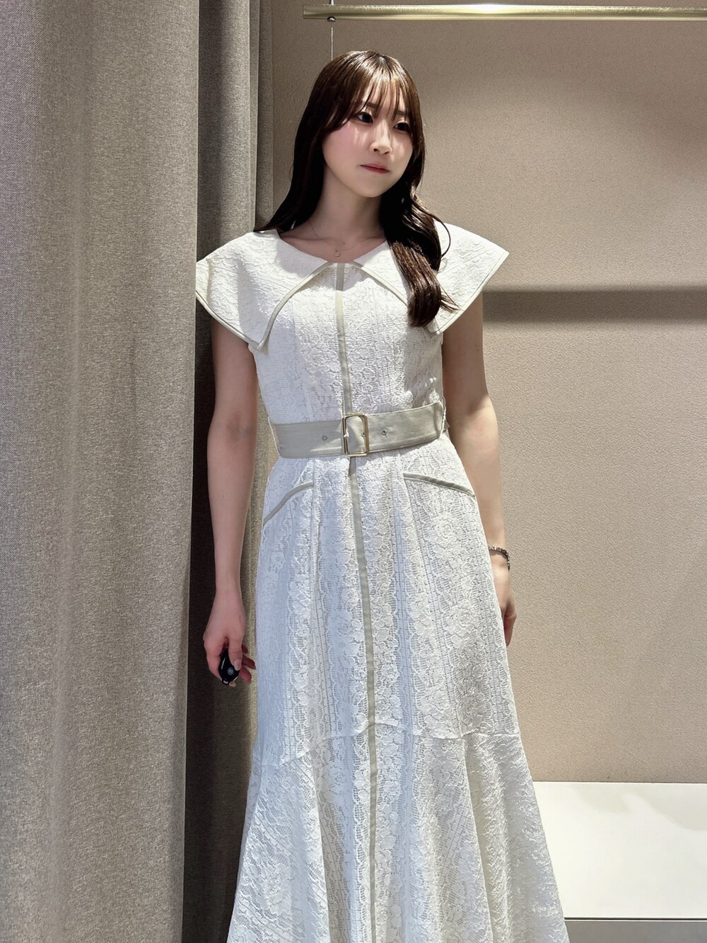 ホワイト系のワンピース、ホワイト系のサンダル、ブラック系のかごバッグを着用したレディースの夏コーディネートの6枚目の写真