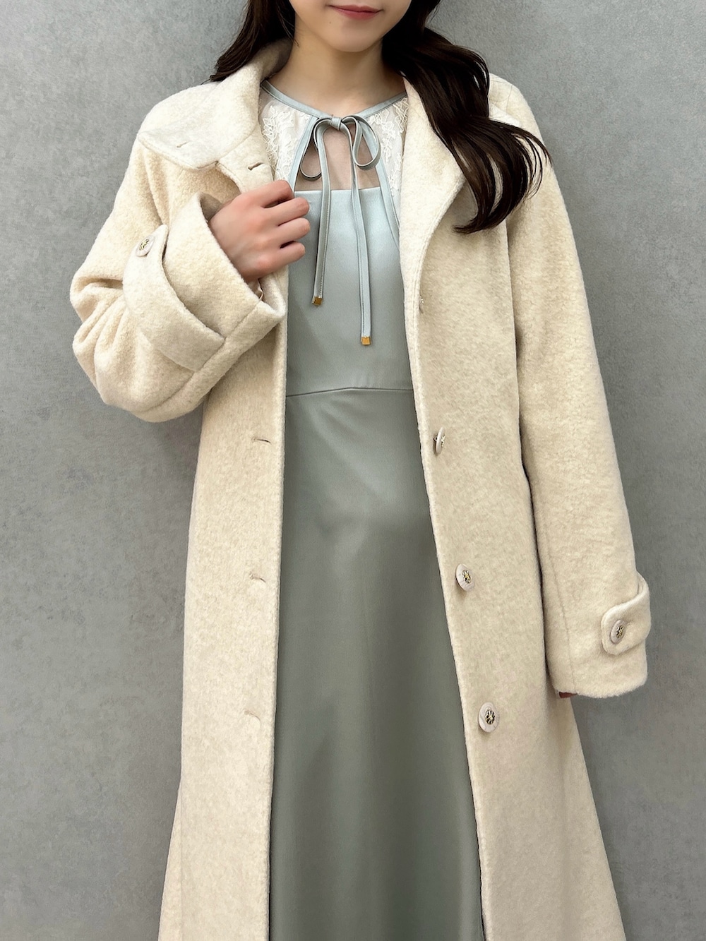 ホワイト系のその他アウター、グリーン系のドレス、ホワイト系のパンプスを着用したレディースの冬コーディネートの5枚目の写真