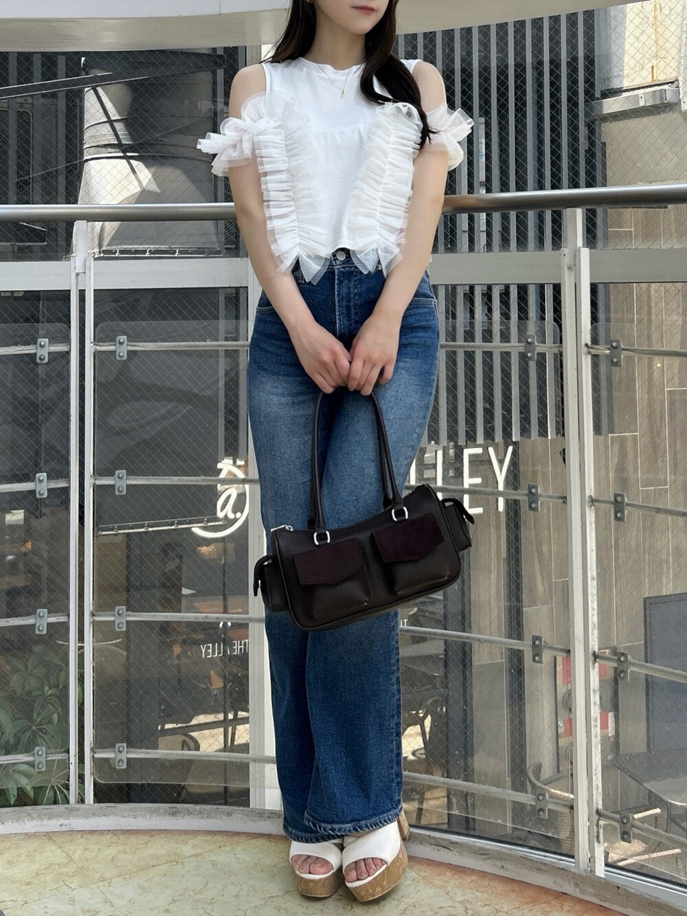 ホワイト系のTシャツ/カットソー、ブルー系のデニムパンツ、ホワイト系のサンダルを着用したレディースの夏コーディネートの2枚目の写真