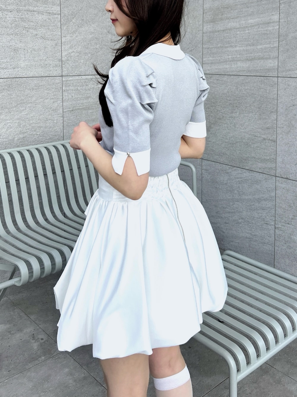 グレー系のニット/セーター、ホワイト系のスカートを着用したレディースの冬コーディネートの8枚目の写真