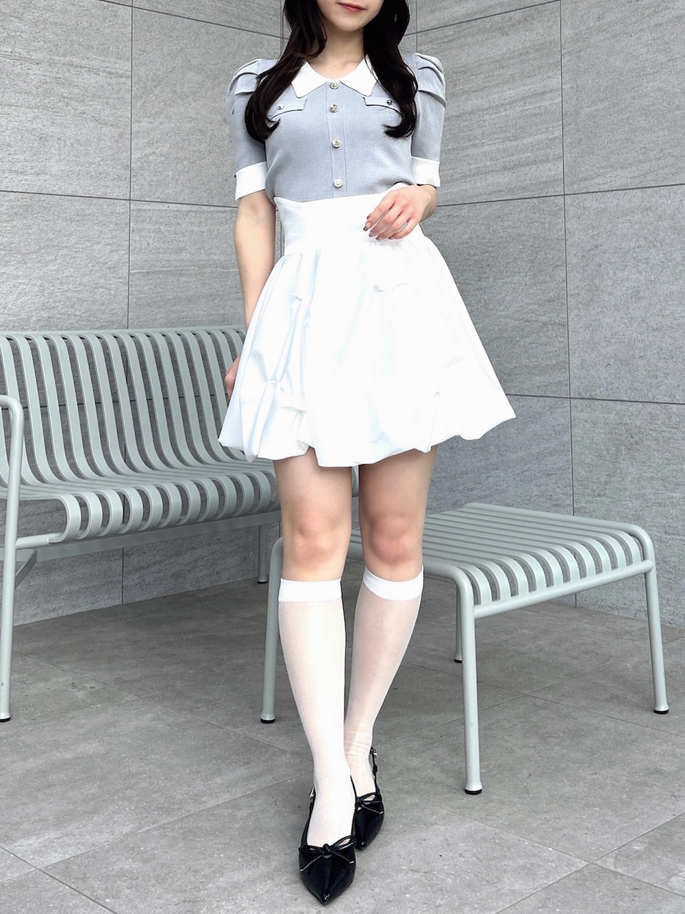 グレー系のニット/セーター、ホワイト系のスカートを着用したレディースの冬コーディネートの4枚目の写真