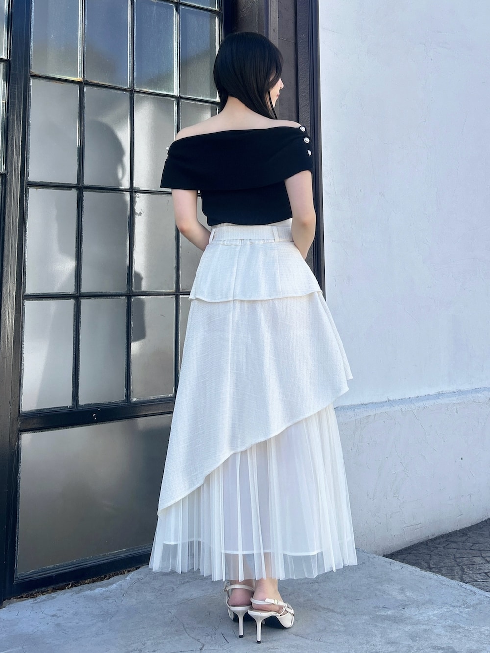 ホワイト系のスカート、ブラック系のニット/セーターを着用したレディースの冬コーディネートの5枚目の写真