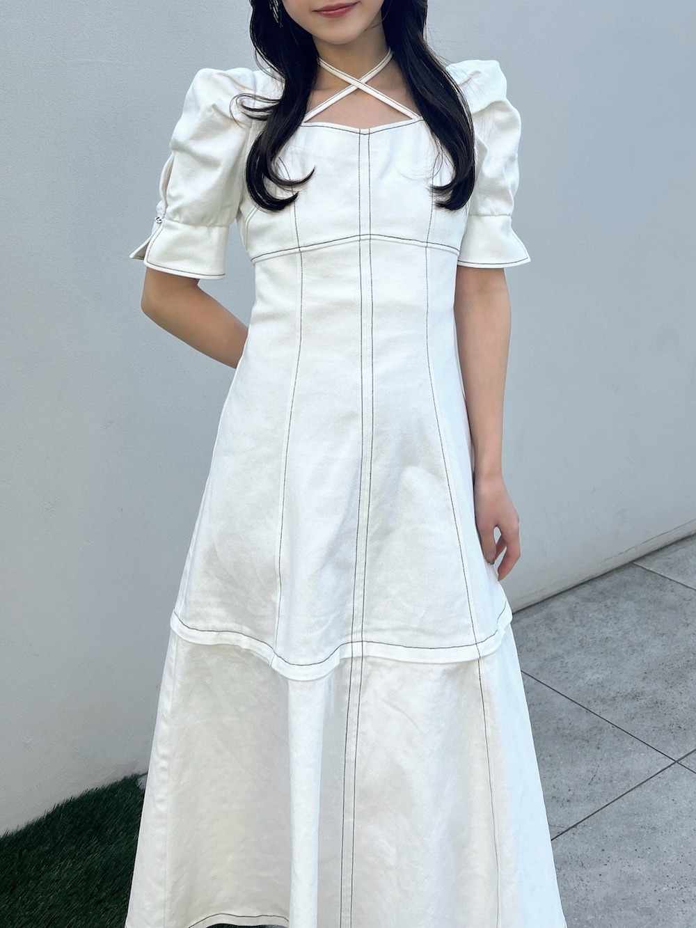 ホワイト系のワンピース、ホワイト系のサンダル、イエロー系のハンドバッグを着用したレディースの春コーディネートの5枚目の写真