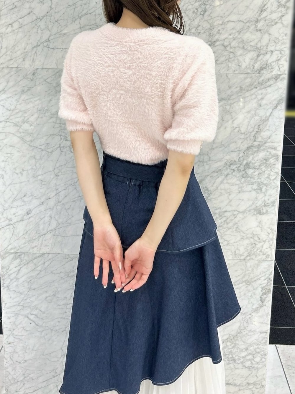 ブルー系のスカート、ブラック系のパンプス、ピンク系のニット/セーターを着用したレディースの秋コーディネートの10枚目の写真