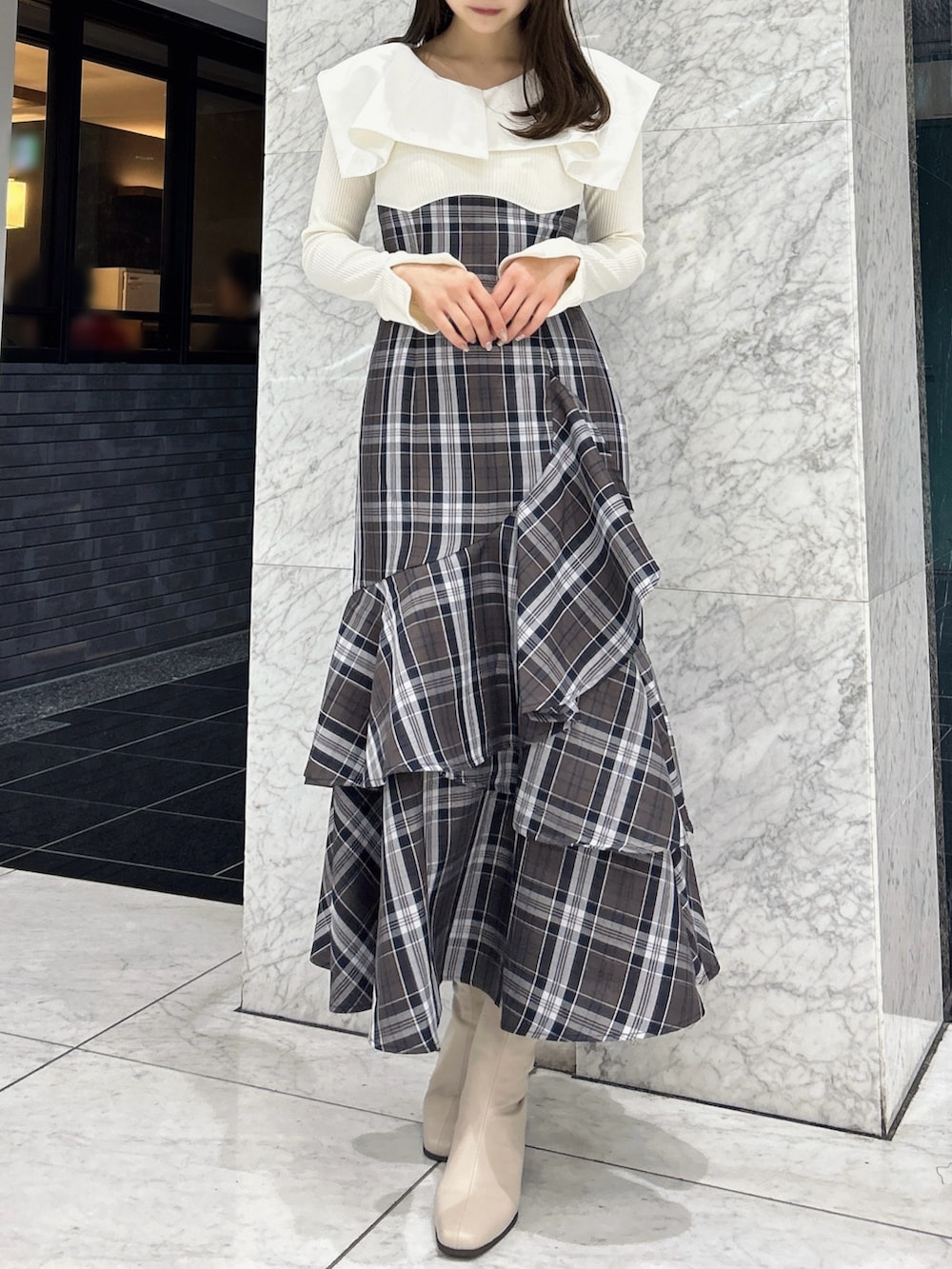 ホワイト系のワンピース、ベージュ系のブーツを着用したレディースの冬コーディネートの2枚目の写真