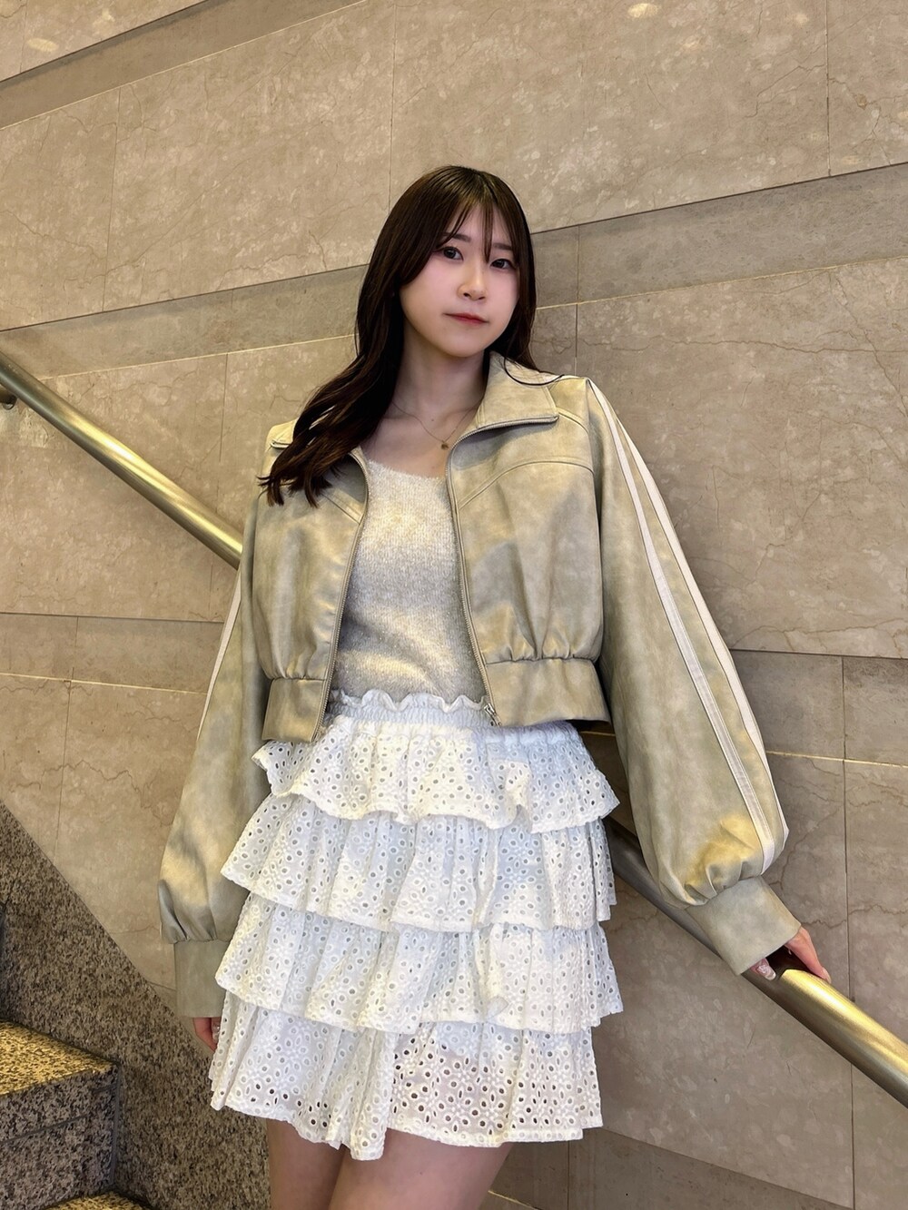 グレー系のブルゾン、ベージュ系のキャミソール、ホワイト系のスカートを着用したレディースの春コーディネートの8枚目の写真