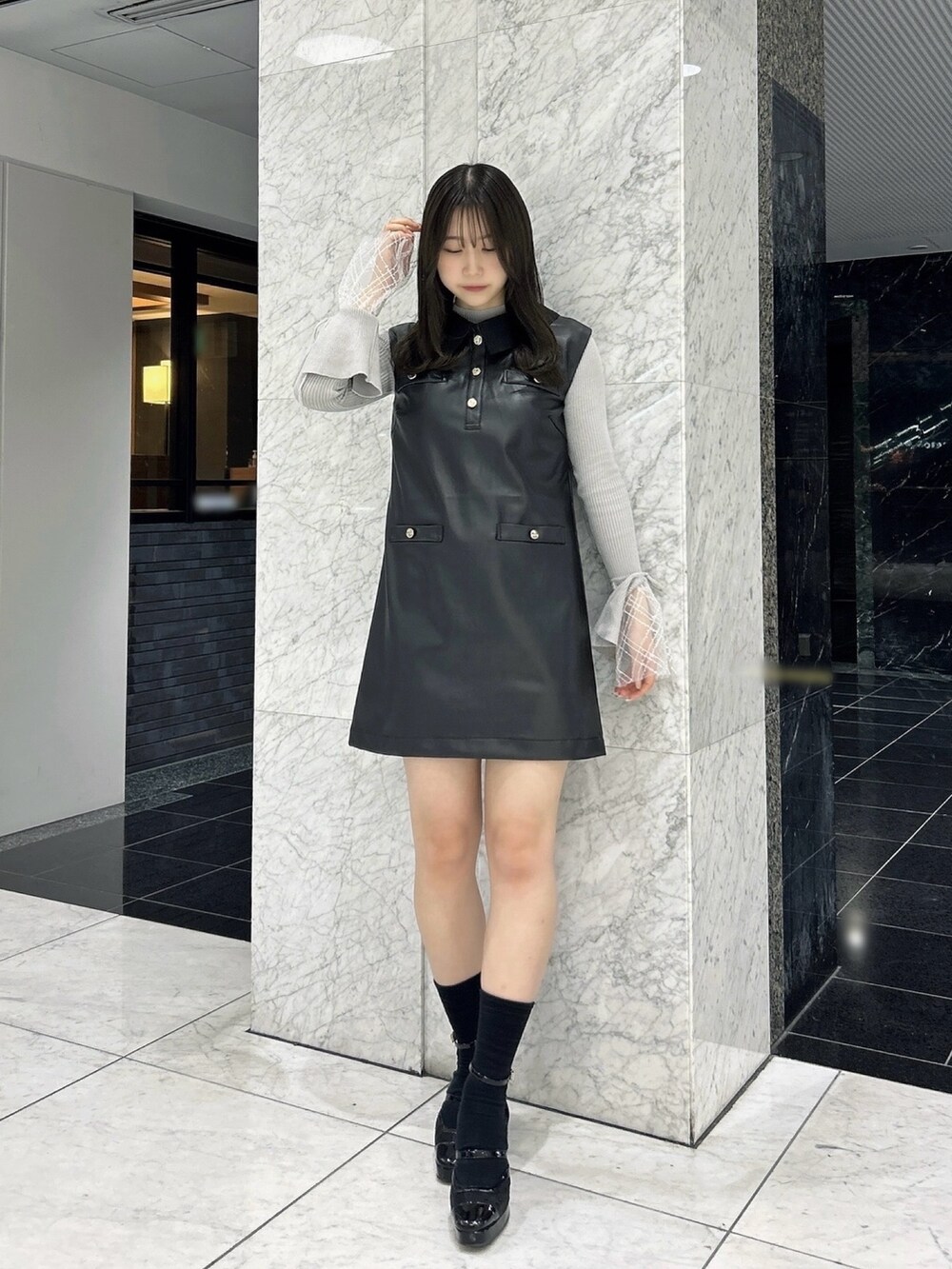 グレー系のニット/セーター、ブラック系のワンピース、ブラック系のパンプスを着用したレディースの秋コーディネートの3枚目の写真