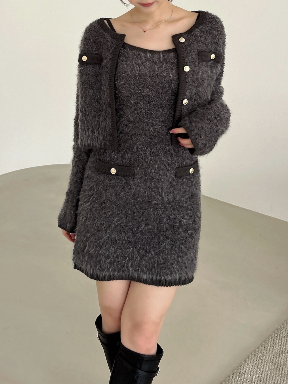 グレー系のノーカラージャケット、グレー系のワンピース、ブラック系のブーツを着用したレディースの冬コーディネートの9枚目の写真