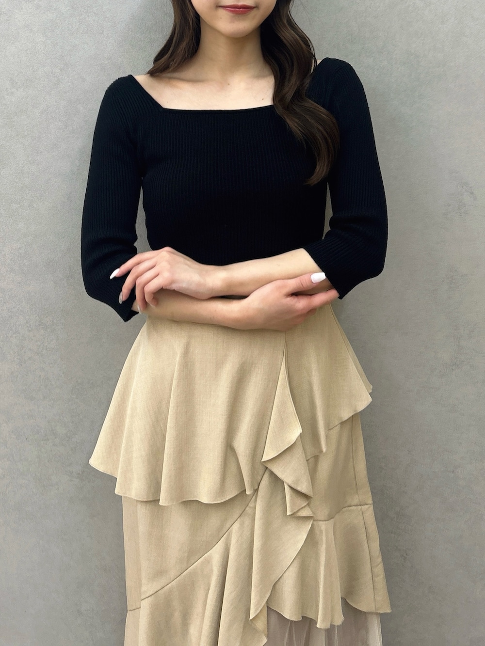 ブラック系のニット/セーター、ベージュ系のスカート、ブラック系のパンプスを着用したレディースの冬コーディネートの7枚目の写真