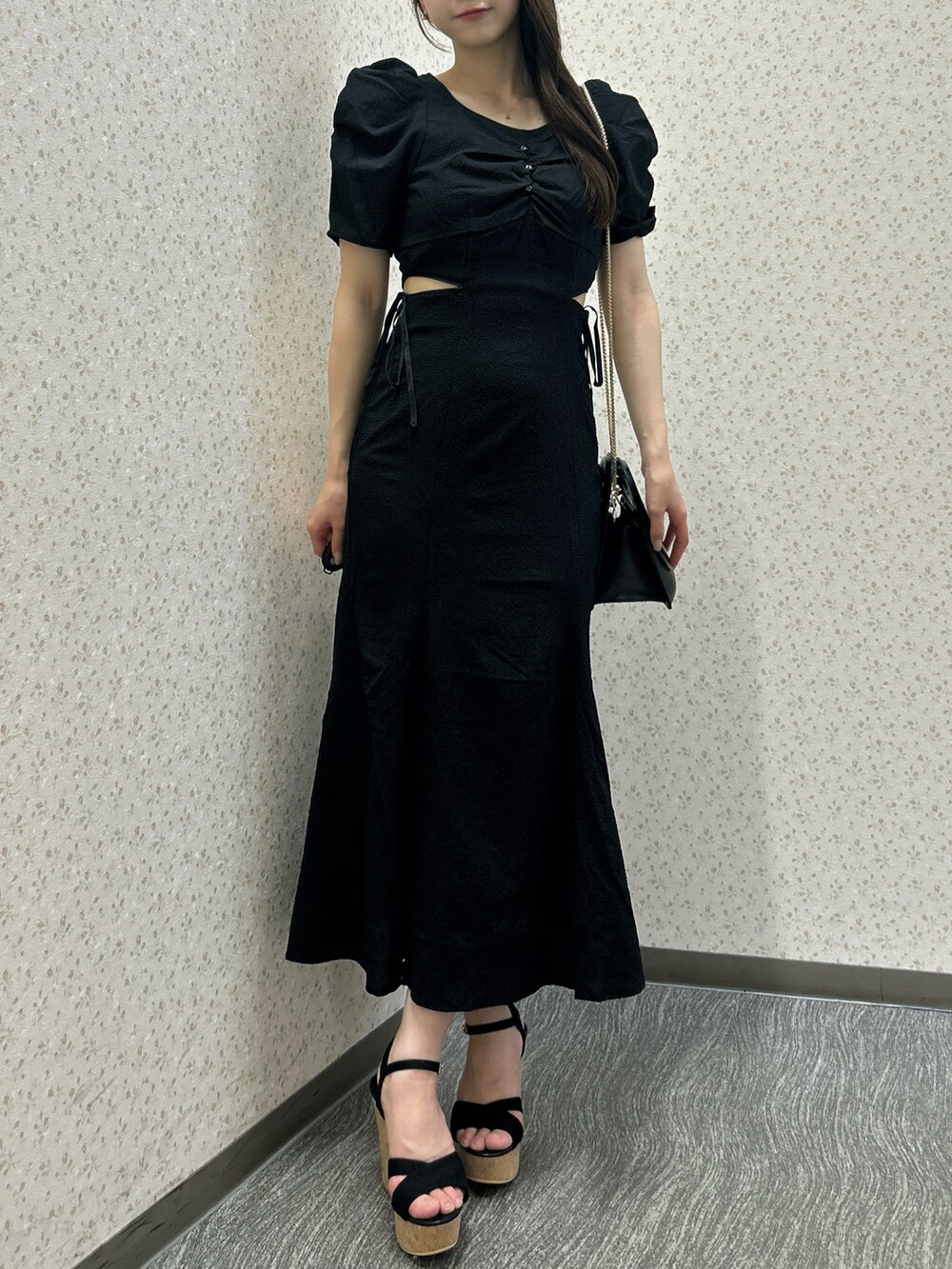 ブラック系のワンピース、ブラック系のハンドバッグ、ブラック系のサンダルを着用したレディースの夏コーディネートの4枚目の写真