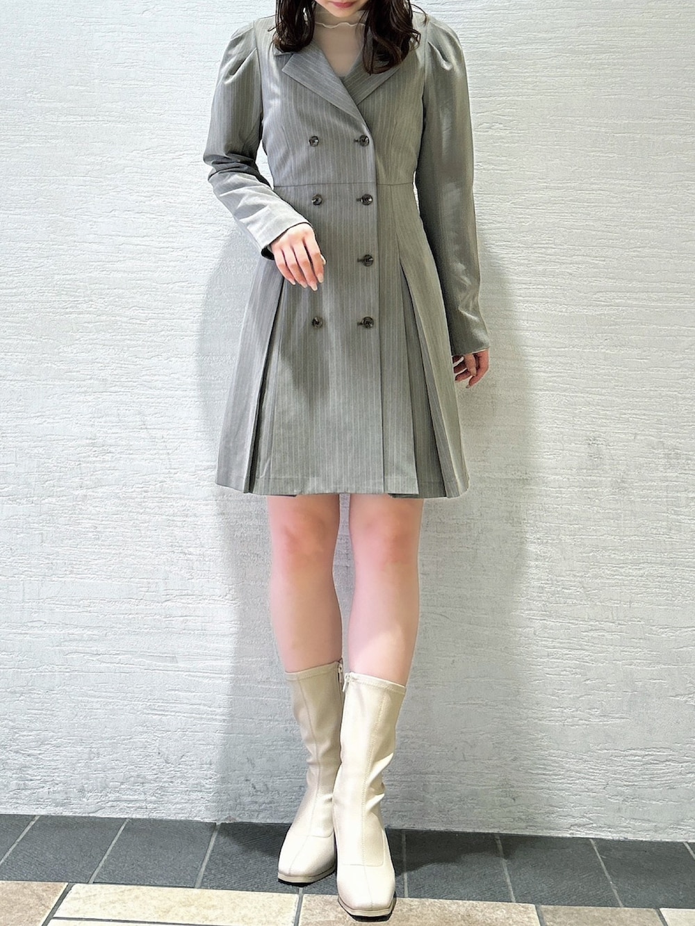 グレー系のワンピース、ホワイト系のTシャツ/カットソー、ホワイト系のブーツを着用したレディースの秋コーディネートの3枚目の写真