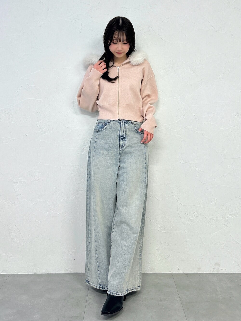 ピンク系のニット/セーター、ブルー系のデニムパンツを着用したレディースの冬コーディネートの4枚目の写真